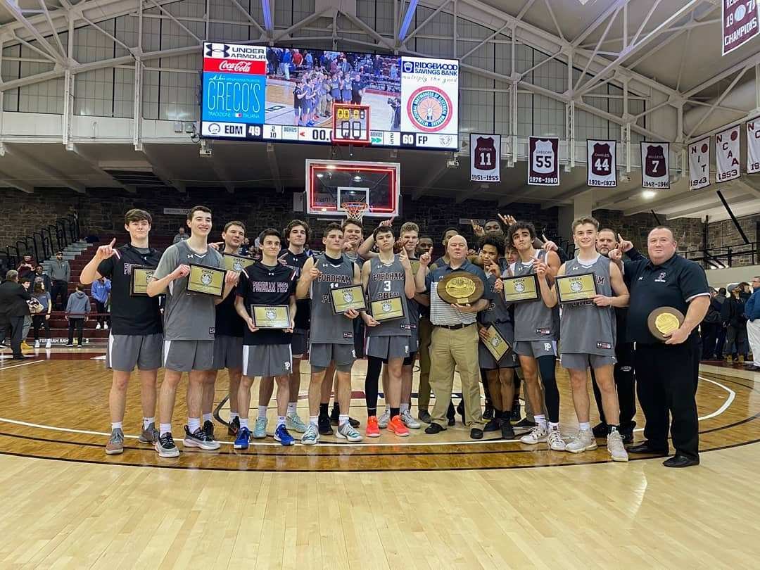 CHAMPIONSHIP MOMENT—Members of the Fordham Prep boys’ basketball team pose with their championship plaques after their 60-49 victory over St. Edmund Prep in the CHSAA intersectional A championship game at Fordham University March 6.